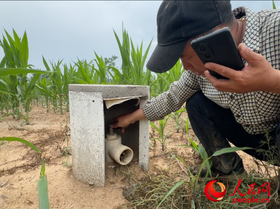 管护人员现场测试浇灌设施，出水口未能出水。人民网记者 游天燚摄